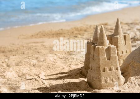 Plage avec château de sable près de la mer par beau temps. Espace pour le texte Banque D'Images