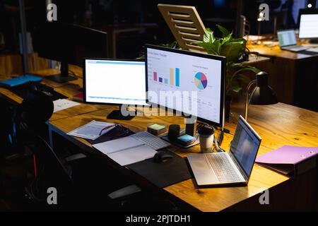 Gros plan sur le bureau avec ordinateur portable, ordinateurs, documents et ordinateur portable, travaillant tard au bureau Banque D'Images