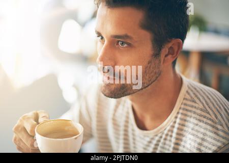 Recueillir ses pensées sur le café. Gros plan d'un jeune homme ayant une tasse de café dans un café. Banque D'Images