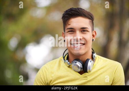 Profitez de la musique et de l'air frais. Portrait d'un jeune homme beau avec un casque autour de son cou. Banque D'Images