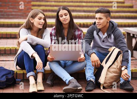 Une vie aimante sur le campus. Photo en plein écran des étudiants de l'université utilisant un ordinateur portable sur le campus. Banque D'Images