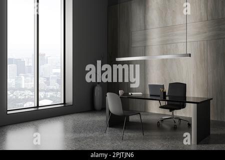 Intérieur de bureau d'affaires moderne et sombre avec ordinateur portable sur le bureau, vue latérale sur le sol en béton gris. Coin PDG avec outils et chaises près du vent panoramique Banque D'Images