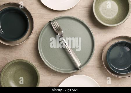 Différentes assiettes, bols et couverts sur table en bois, plat Banque D'Images