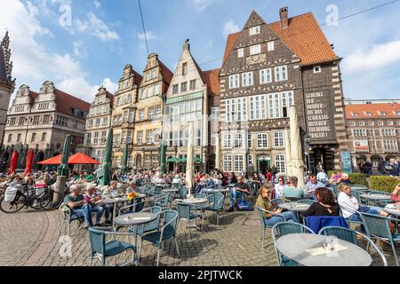 Les gens dans les cafés de la place du marché de Brême - Marktplatz à Am Markt. Maisons à pignons de la Renaissance du 16e siècle avec Rathscafe Deutsches Haus (à droite). Brême Banque D'Images