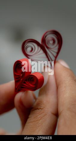 Concept de la Saint-Valentin. Cœur en papier rouge à la main. Remplissage de l'artisanat du papier Banque D'Images