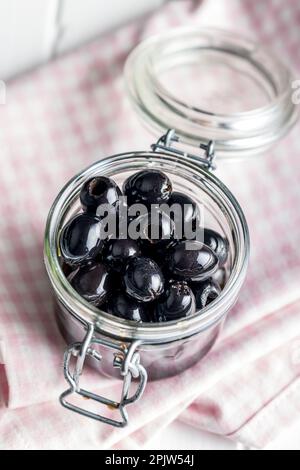 Olives noires dénoyautées dans le bol. Banque D'Images