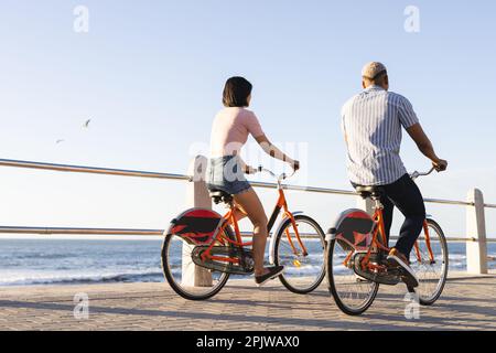 Divers couples en vélo le long de la promenade au bord de la mer Banque D'Images