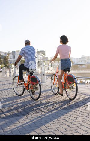 Divers couples en vélo le long de la promenade au bord de la mer Banque D'Images