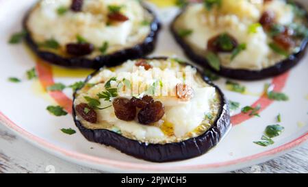 Tranches d'aubergines cuites au four avec fromage et raisins secs. Banque D'Images