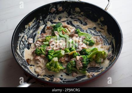 Brocoli cuisiné à la crème italienne de style carbonara avec du bacon. Banque D'Images