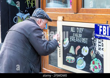 Homme portant un chapeau en train de manger à l'extérieur du restaurant pendant le confinement des covidés. Bruxelles. Banque D'Images