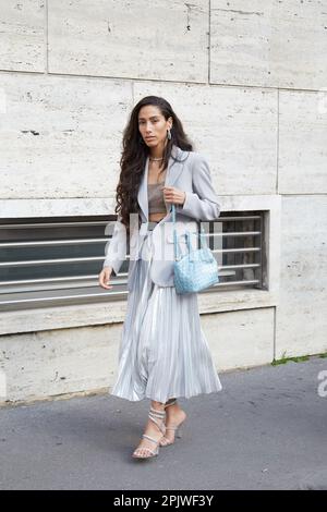 MILAN, ITALIE - 25 FÉVRIER 2023 : femme avec sac bleu clair, jupe plissée argentée et veste grise avant le spectacle de mode Missoni, Milan Fashion week stre Banque D'Images
