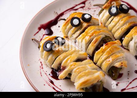 Recette d'Halloween. Poivrons verts frits en forme de momie. Banque D'Images