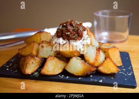 Papas bravas, sont une préparation typique de bars en Espagne, consistant en pommes de terre coupées en gros cubes, frits dans l'huile d'olive et assaisonnés avec de la salsa brava Banque D'Images