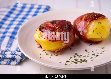 Pommes de terre cuites enveloppées de jambon serrano. Tapa traditionnel espagnol. Banque D'Images