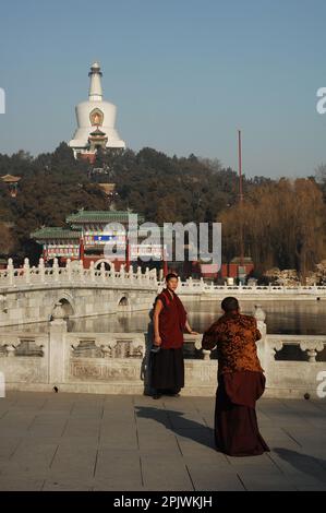 Moines en voyage au parc de Beihai dominé par le grand Stupa blanc. Pékin, Chine Banque D'Images