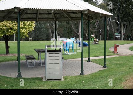 Un abri de pique-nique avec une table et des chaises dans un parc public avec de l'herbe verte. Banque D'Images