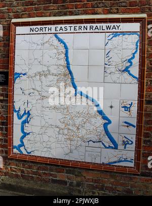 Sur un mur de la plate-forme de Hull à Hunmanby dans le North Yorkshire se trouve une carte en mosaïque des lignes des anciennes compagnies de chemin de fer du Nord-est. Banque D'Images