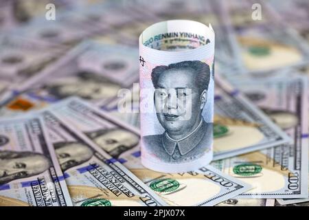 Le billet de banque chinois en yuans a roulé sur fond de dollars américains. Concept de guerre commerciale entre la Chine et les Etats-Unis, économique, sanctions et investissement Banque D'Images