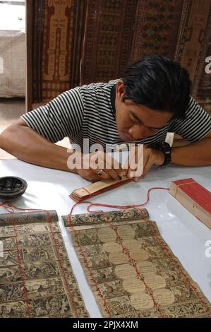 Calligraphie traditionnelle sur la feuille de palmier séchée au village de Tenganan à l'est de Bali, Bali. Banque D'Images