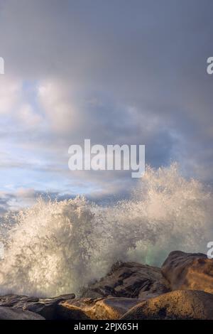 De fortes vagues secouent les récifs et forment une grande quantité de mousse Banque D'Images