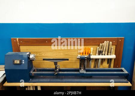 Supports de tours en bois dans l'atelier de menuiserie. Arrière-plan. Fraiseuse avec outils pour le traitement des produits en bois contre les murs. Copier l'espace... Banque D'Images