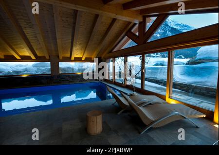 La piscine chauffée face à la neige de l'hôtel Sant'Orso dans la ville de Cogne, au pied du groupe Gran Paradiso. Vallée d'Aoste, Italie, Euro Banque D'Images