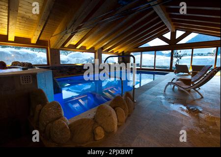 La piscine chauffée face à la neige de l'hôtel Sant'Orso dans la ville de Cogne, au pied du groupe Gran Paradiso. Vallée d'Aoste, Italie, Euro Banque D'Images