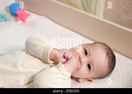 Mère faisant un massage sur son bébé en bonne santé. Femme attentionnée faisant de la gymnastique à petit bébé. Banque D'Images