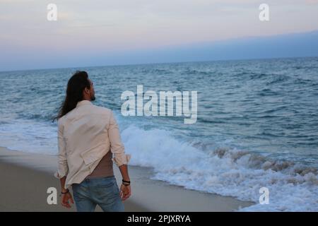 Long cheveux homme plage Banque D'Images