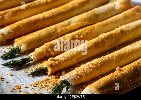 Asperges enrobées de pâte phylo et cuites au four. Gros plan, ci-dessus. Banque D'Images