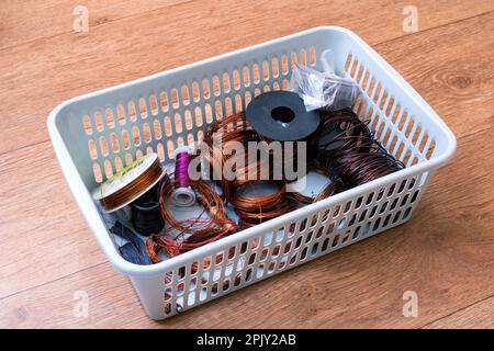 Les bobines de fil de cuivre dans un panier en plastique se rapprochent Banque D'Images