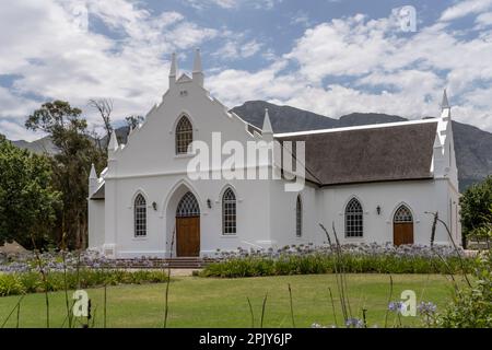 Paysage urbain avec église réformée hollandaise, tourné dans la lumière d'été lumineuse, Franschhoek, Western Cape, Afrique du Sud Banque D'Images