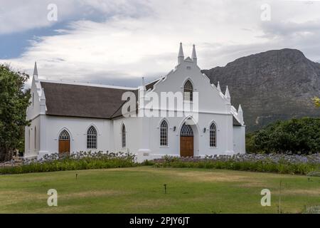 Paysage urbain avec église réformée hollandaise blanche, tourné dans la lumière d'été lumineuse, Franschhoek, Western Cape, Afrique du Sud Banque D'Images