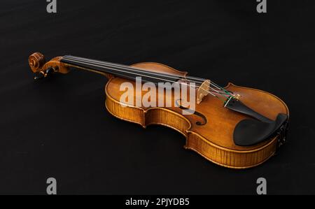 Image rapprochée d'un violon reposant sur un arrière-plan sombre Banque D'Images