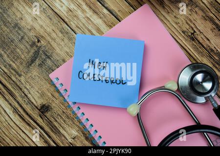 Concept de High Colesterol écrire sur des notes adhésives avec stéthoscope isolé sur la table en bois. Banque D'Images