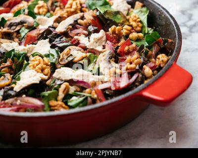 Épeautre avec du bard suisse rouge, des champignons, des noix et des feta végétaliens dans une casserole en fonte. Banque D'Images