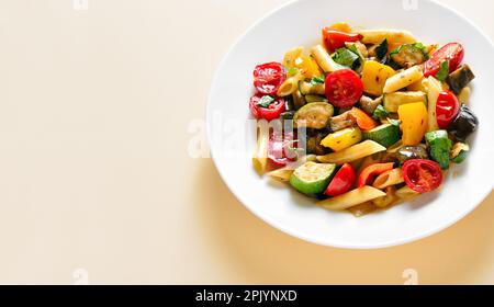 Fermez l'upiew de salade de pâtes à la ratatouille sur l'assiette sur un fond clair avec l'espace de copie. Banque D'Images