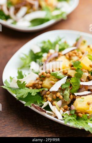 Salade de lentilles tropicales avec des chips d'ananas et de noix de coco. Banque D'Images