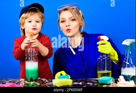 Un petit garçon et une mère avec des produits de nettoyage. Une famille heureuse nettoie la maison. Nettoyage du ressort. Ménage et ménage en famille. Mignon petit assistant. Fils Banque D'Images