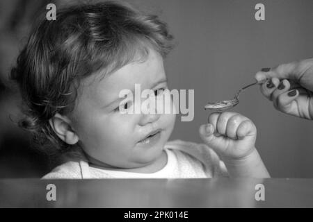 Nourrir bébé. Pas faim. Enfant refusant de manger. L'enfant n'a pas d'appétit. Un petit enfant contrarié refuse de manger de la soupe. Une alimentation saine pour les enfants. Banque D'Images