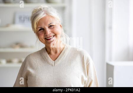 Portrait d'une femme âgée souriante regardant l'appareil photo Banque D'Images