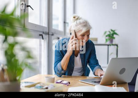 Portrait d'une femme d'affaires mûre souriante travaillant dans un bureau Banque D'Images