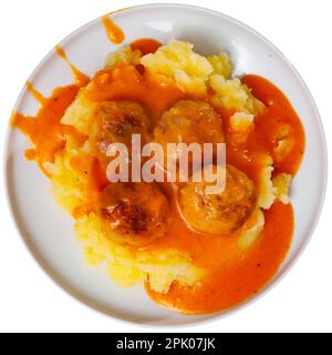 assiette ronde blanche avec boulettes de viande saupoudrées d'aneth haché dans une sauce tomate avec purée de pommes de terre Banque D'Images