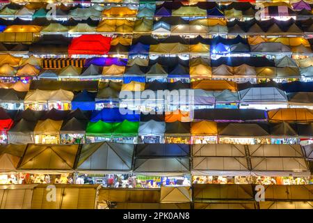 Vue rapprochée du marché de nuit extérieur ou des tentes de foire et des stands de nourriture. Banque D'Images