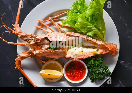 homard frais ou fruits de mer de langouste avec herbes et épices citron coriandre salade de laitue de persil, nourriture de langouste sur l'assiette, homard pour la cuisson du foo Banque D'Images