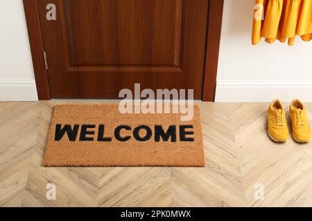 Tapis de porte avec mot Welcome sur parquet dans le hall Banque D'Images