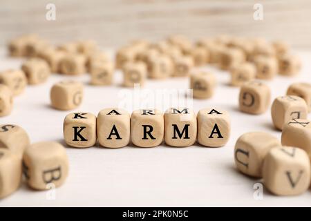 Mot Karma fait de cubes avec des lettres sur la table blanche Banque D'Images