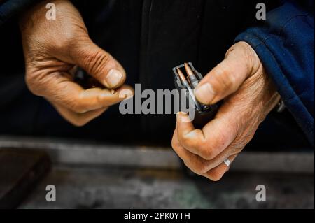 Un employé expérimenté dépose des balles dans le magazine d'armes à feu de l'usine Banque D'Images