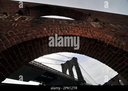 Le Pont de Brooklyn, vu à travers une fenêtre de l'ancien entrepôt de tabac à Fulton Landing State Park, New York City, USA Banque D'Images